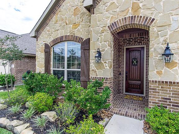 Brick/stone elevation with a pretty front door to welcome your guests.