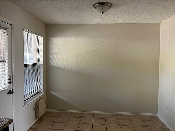 Tiled spare room featuring a textured ceiling