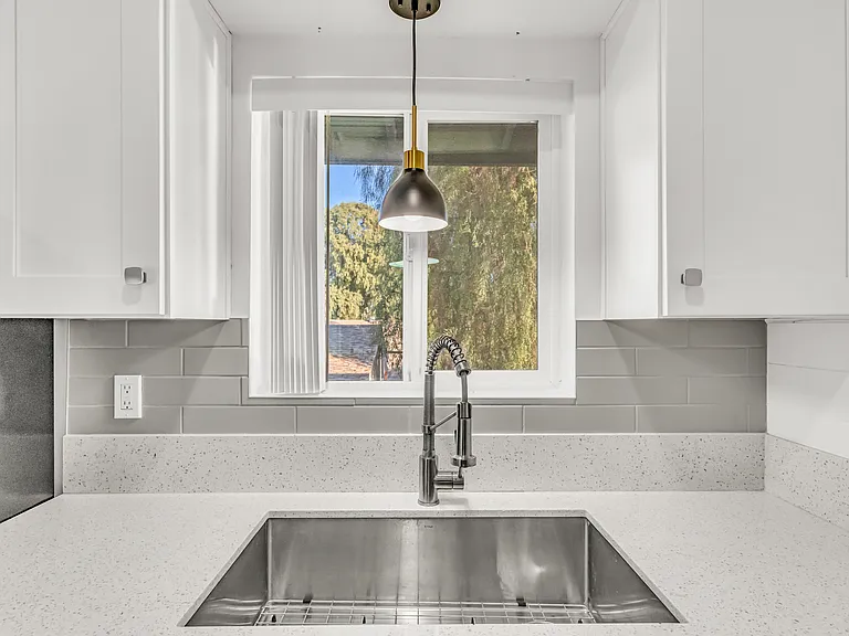 Quartz countertops with drop-in sink, tile backsplash and upgraded lighting
