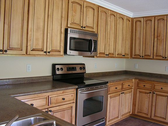 Beautiful eat in kitchen with custom cabinets and stainless steel appliances.
