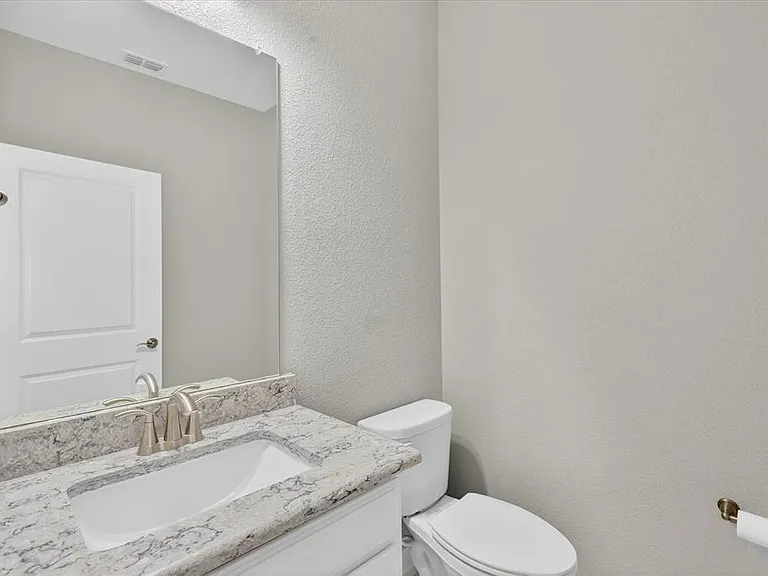 Bathroom vanity featuring an undermount sink, a countertop with visible veining, and a brushed nickel faucet