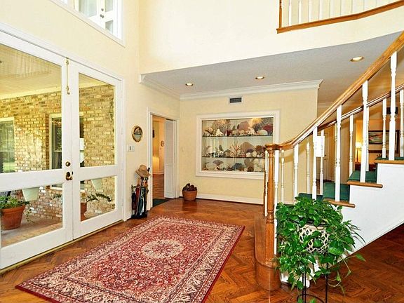  This view shows the front entrance to this home. Notice the large double glass doors. This home is full of sunshine with many, many Full light French doors. The foyer light is on a crank that allows the owner to clean the fixture with ease.