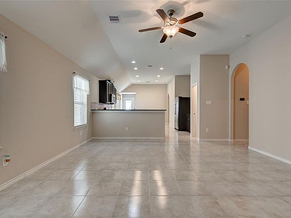 16x15 Family - High ceilings and open concept give this home a spacious feeling. Kitchen and dining are in the background. Two bedrooms and hall closet are to the right while the primary bedroom is in the around the corner from the dining.