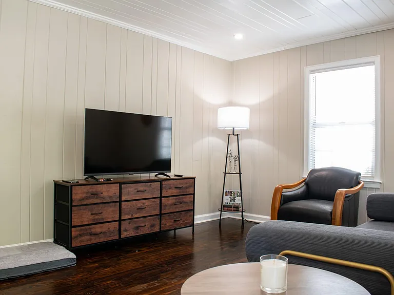 Shared living area with seating, TV setup, and a window for natural lightideal for relaxing or streaming after work.