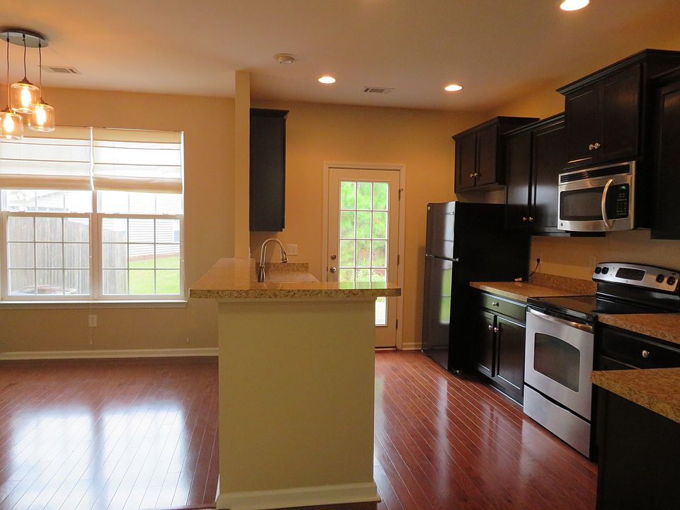 Dining on left, Eat-In bar, Kitchen. View to backyard through French door. *Note - Upgraded lighting in Dining, recessed can lights in kitchen