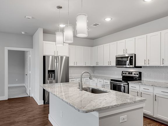 Modern kitchens with stone counter-tops and tile back-splash.