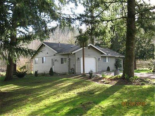 Evergreens and gardens give this lovely home a park like feel!