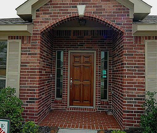 The front entry is gorgeous with stunning wood door, covered entry and side-lights.