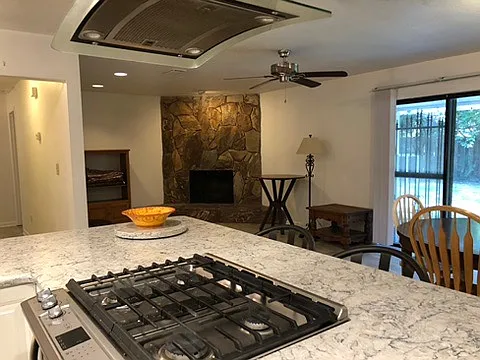 View from kitchen looking into living room showing newly remodeled kitchen with gas stove and sliding doors to screened in porch