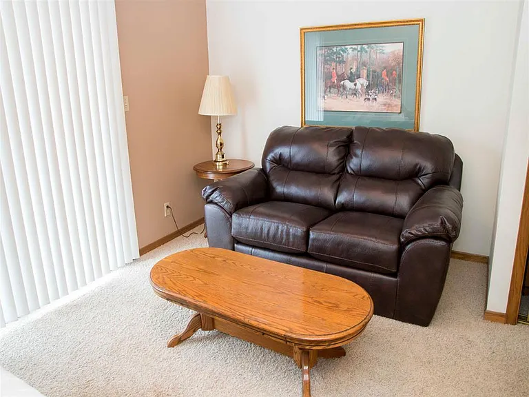 Kick back in a comfy living space with plush carpet, natural light, and room to relax.