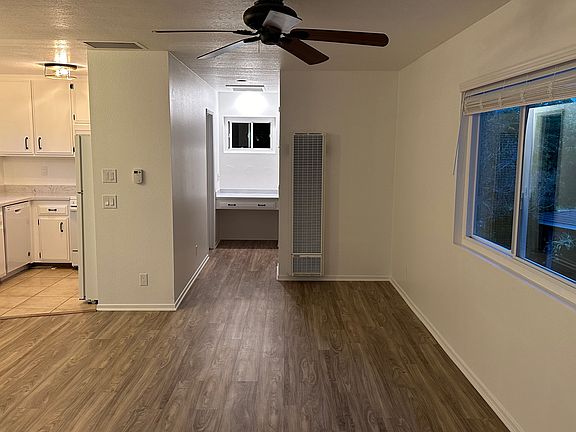 Living area with ceiling fan, wall furnace and attic fan.