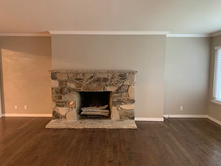 Wood burning fireplace in large sunny living room
