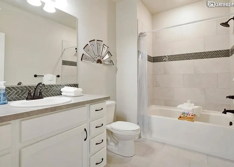 Secondary bath with tub/shower combo & modern tile accents