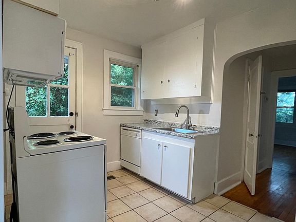 refreshed kitchen with build-in microwave, dishwasher, stove, and refrigerator.