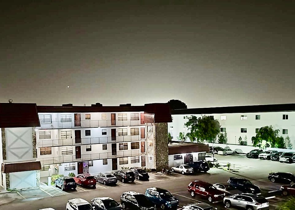 VIEW OF BUILDING AND PARKING AREA