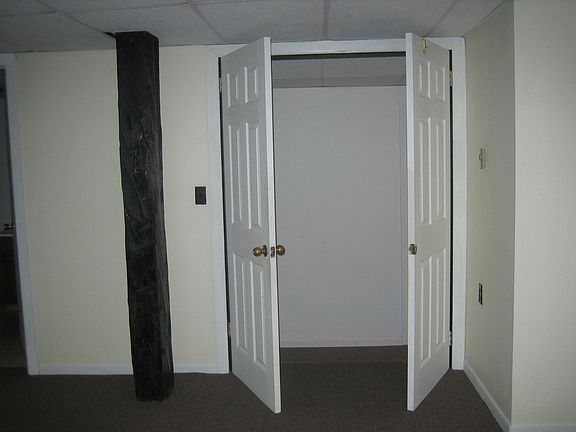doors dividing small bedroom and kithen area from living roo