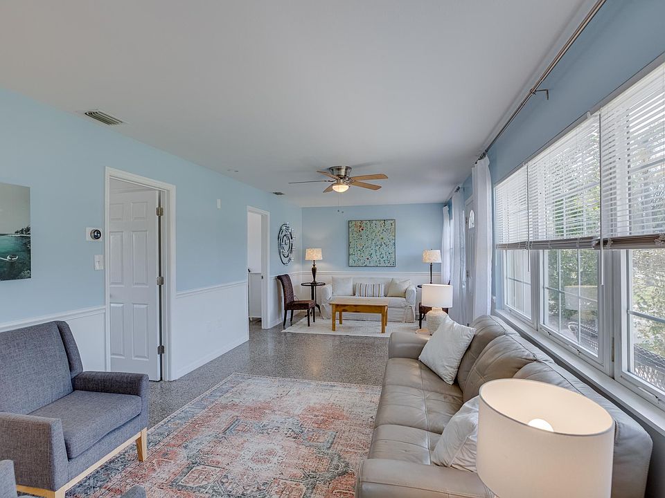 Large furnished living room with terrazzo floor, adjacent to two bedrooms