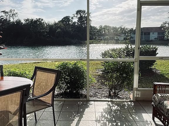 Private patio rattan couch, eating area for coffee, breakfast and wine overlooking small Fl lake