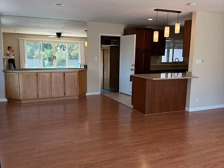 view of large formal dining room attached to galley kitchen, includes buildt in buffet, large mirror, and bay window