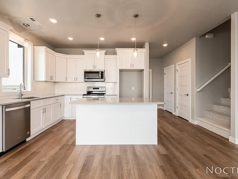 Beautiful kitchen and dining area in an open living space. (Photo of another unit with similar finishes and quality.)
