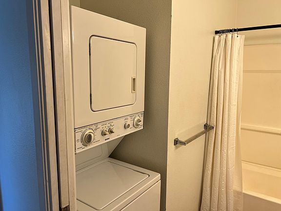 Indoor washer dryer unit in the full hallway bathroom behind pocket door