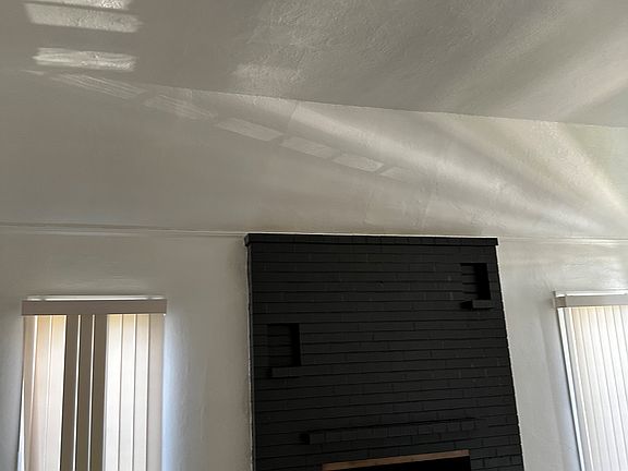 Entering from front door, view of tall ceiling and fireplace