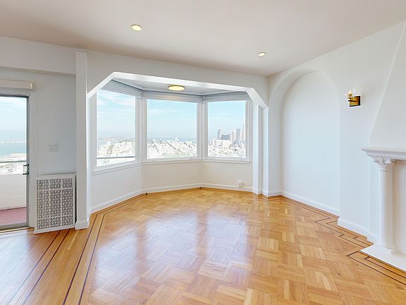 Living area with two large windows and wood-like flooring