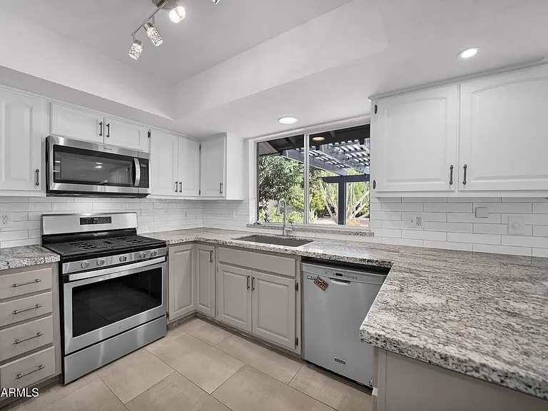 Modern kitchen with new stainless steel appliances and granite countertops.