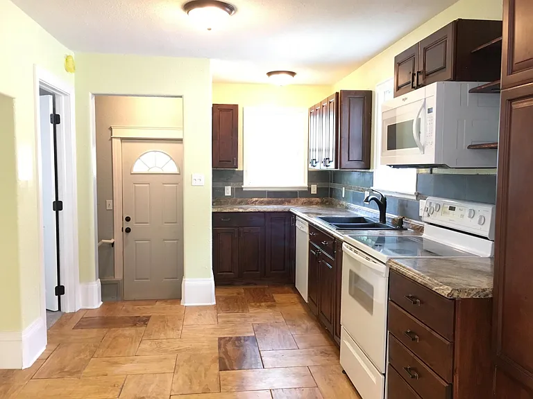 Kitchen and backdoor. To the left is a bedroom on the main level.