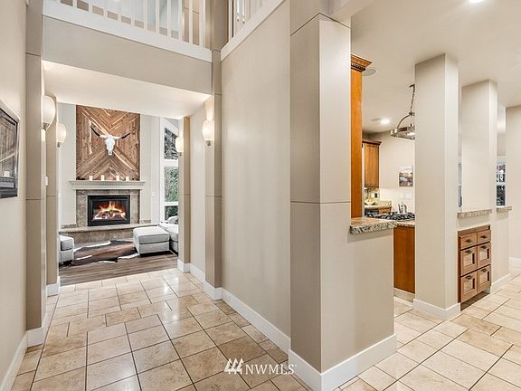 Entry hall shows the kitchen to the right and great room toward the back. Travertine tile and new LVP throughout the main floor!