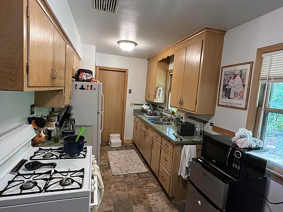 Kitchen with pantry and vent fan over the stove.