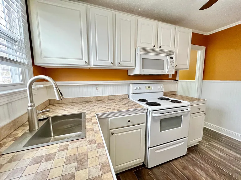 Custom tile counters, spice niche shelving, white cabinets and Vinyl Low E Window.