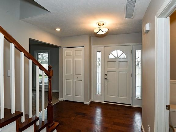 Pictured: Foyer entry with main staircase, great room entry, and coat closet on the left. To the right, is the 1st floor powder room.