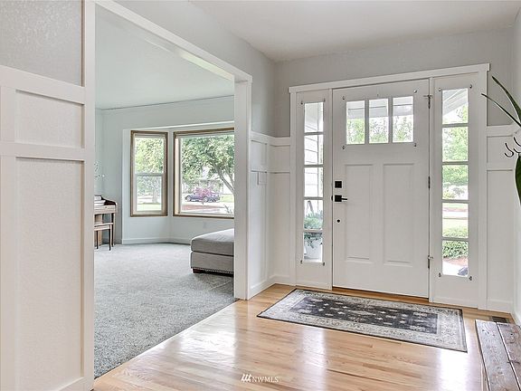View from coat closet to main entrance, living room to left, look at the beautiful floors and bay window! 