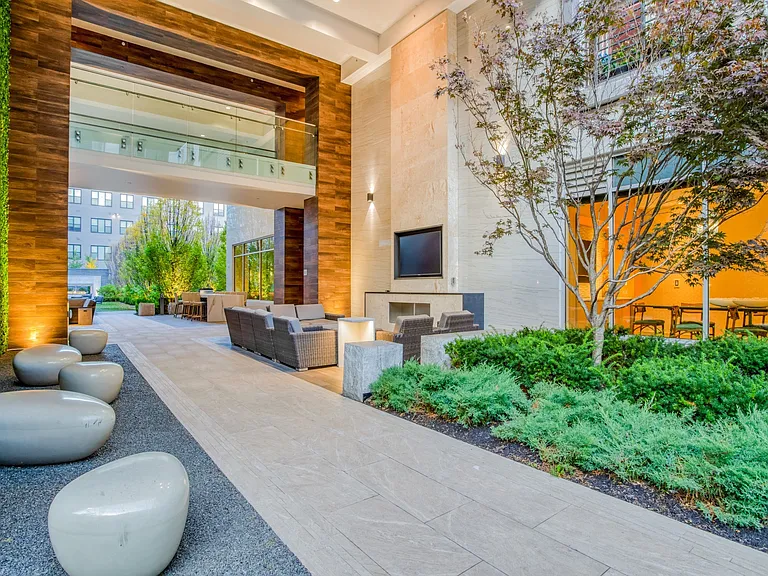 Outdoor entertainment space that's outfitted with a TV, fireplace and abundant seating.