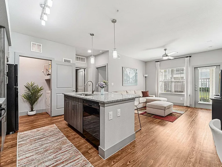 Experience modern living with expansive city views in this open-concept kitchen and living room at The Broadway in Houston, TX.