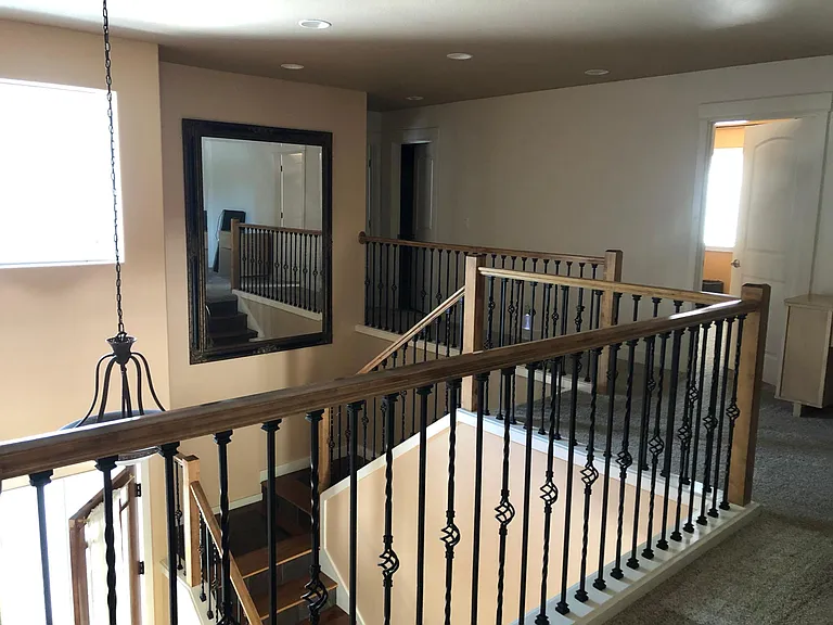 Wooden stairs to the upper floor with open style iron railings
