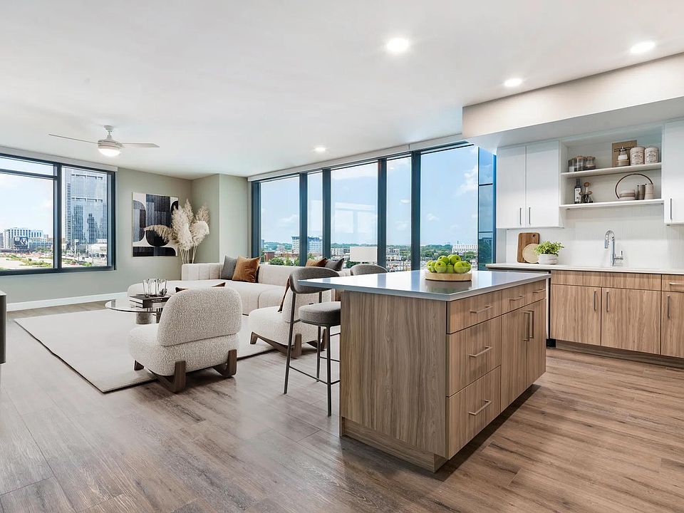 Enjoy a modern kitchen with 42" soft-close cabinetry with under cabinet lighting, quartz counters, and open shelving for added function and style.