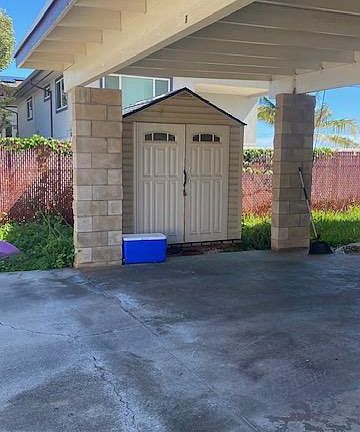 Covered carport for two vehicles and storage shed