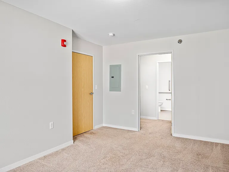 Bright and inviting apartment interior with plush carpeting and modern fixtures, leading to a sleek bathroom. Bright and inviting apartment interior with plush carpeting and modern fixtures, leading to a sleek bathroom.