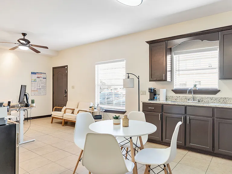 Interior of a kitchen at Merida Vista Apartments, with a dining table, chairs, and storage cabinets arranged neatly