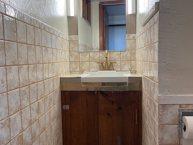 Basement Powder Room Sink - New lights around mirror and new golden faucet.