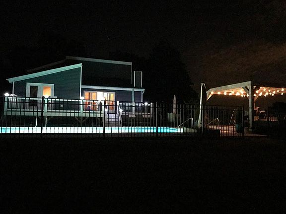 Pool and decks at night with lights.