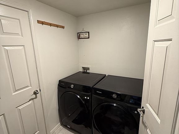 Entry way from garage with front loader Samsung washer and dryer.