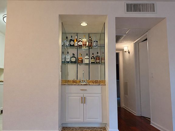Built-in wet bar with mirrored glass shelving and granite counter _ a WeHo entertainer's dream