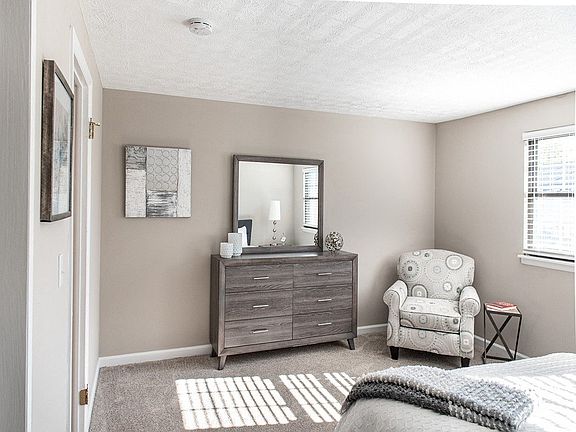 Another view of spacious primary bedroom with wall-to-wall carpeting & closet