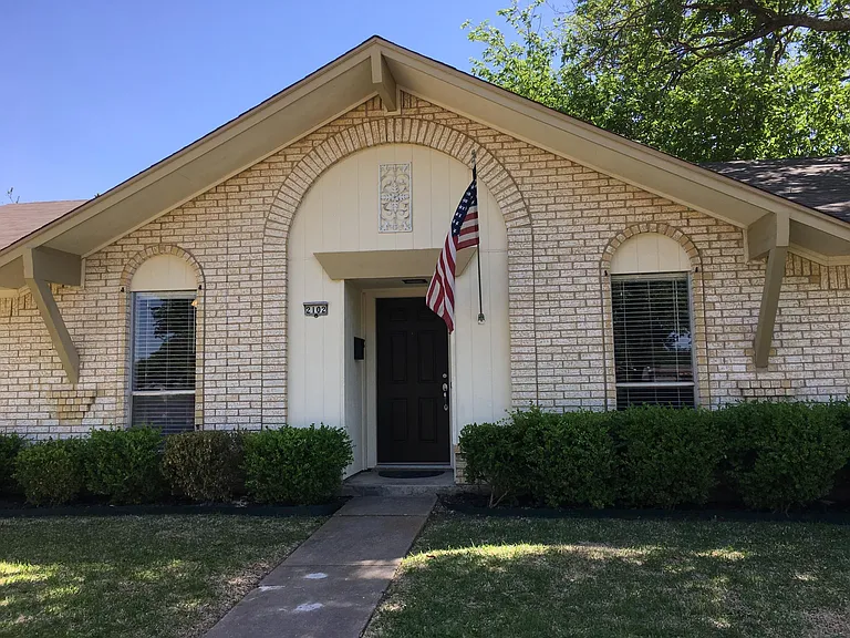 Majestic arched brick trim outlines the tall windows and door
