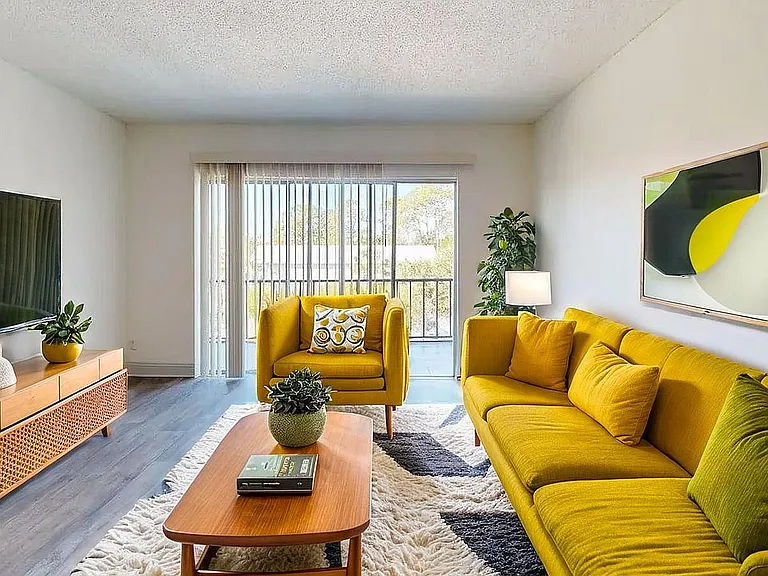Modern living room with vibrant yellow seating, stylish wood furniture, and large window for natural light.