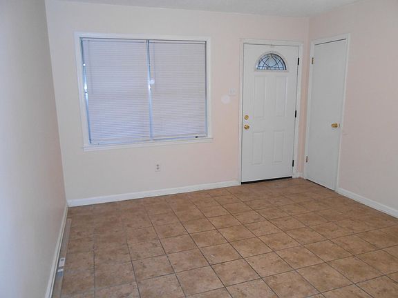 Living room with window and front entry door in the background