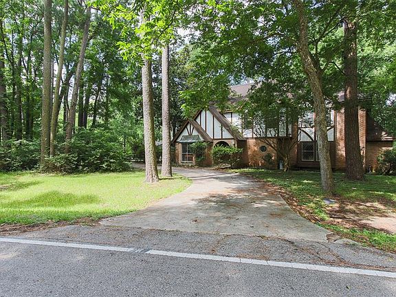 Circular driveway can accommodate few cars, and corner tree lined lot provides plenty of privacy.